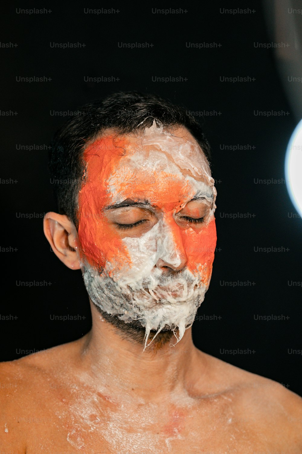 a man with orange and white paint on his face