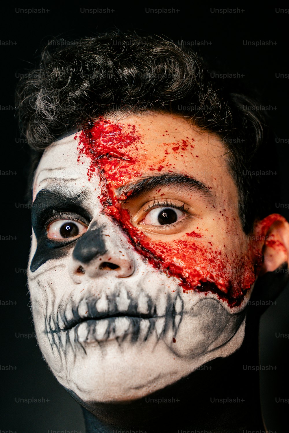 Ein Mann mit einem bemalten Totenkopf im Gesicht