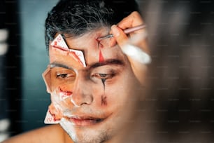 a man is getting his face painted with white paint