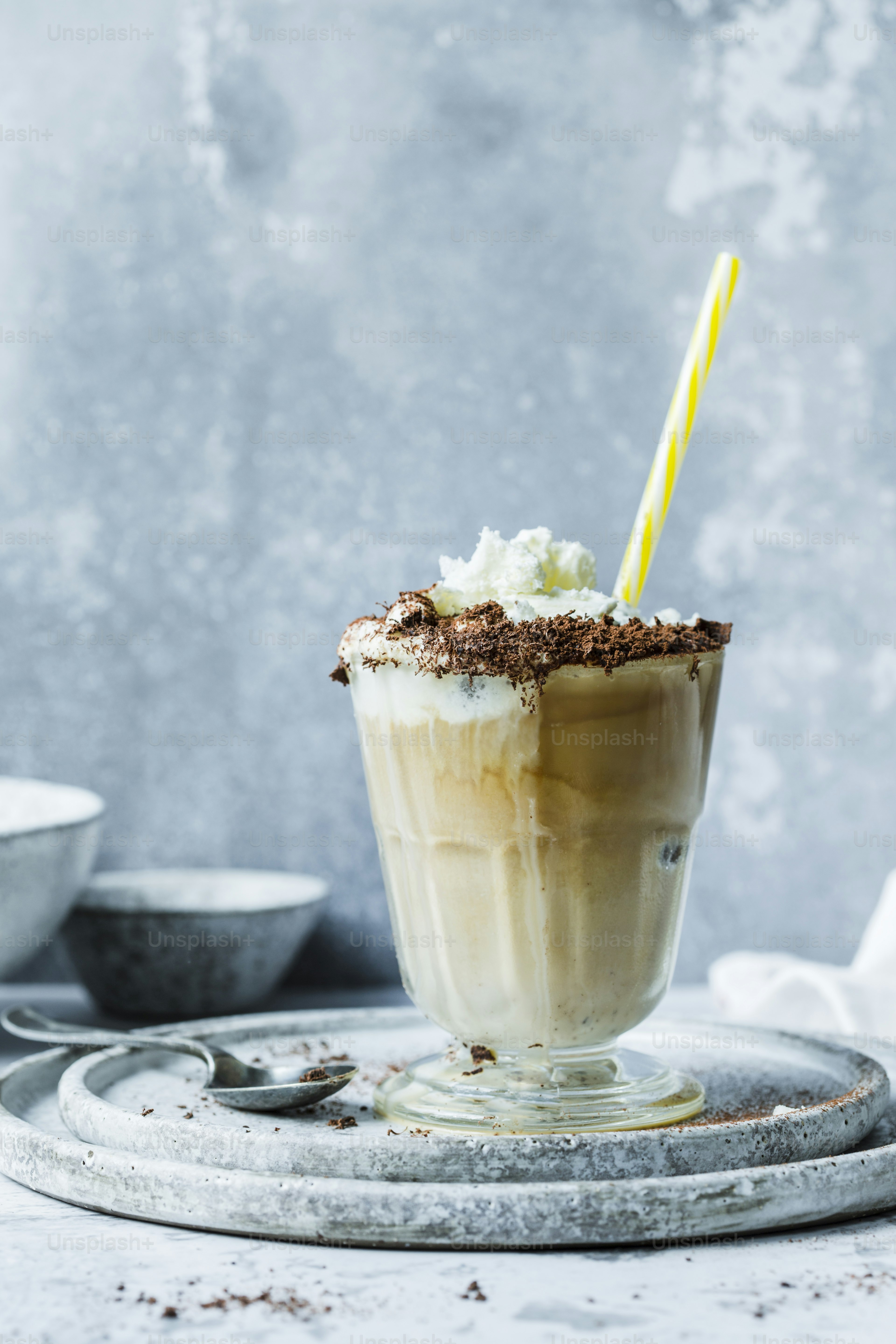 uma xícara de sorvete com um canudo listrado amarelo
