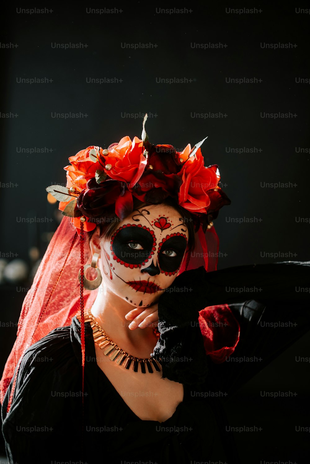 eine Frau, die eine Skelettmaske und einen roten Schleier trägt