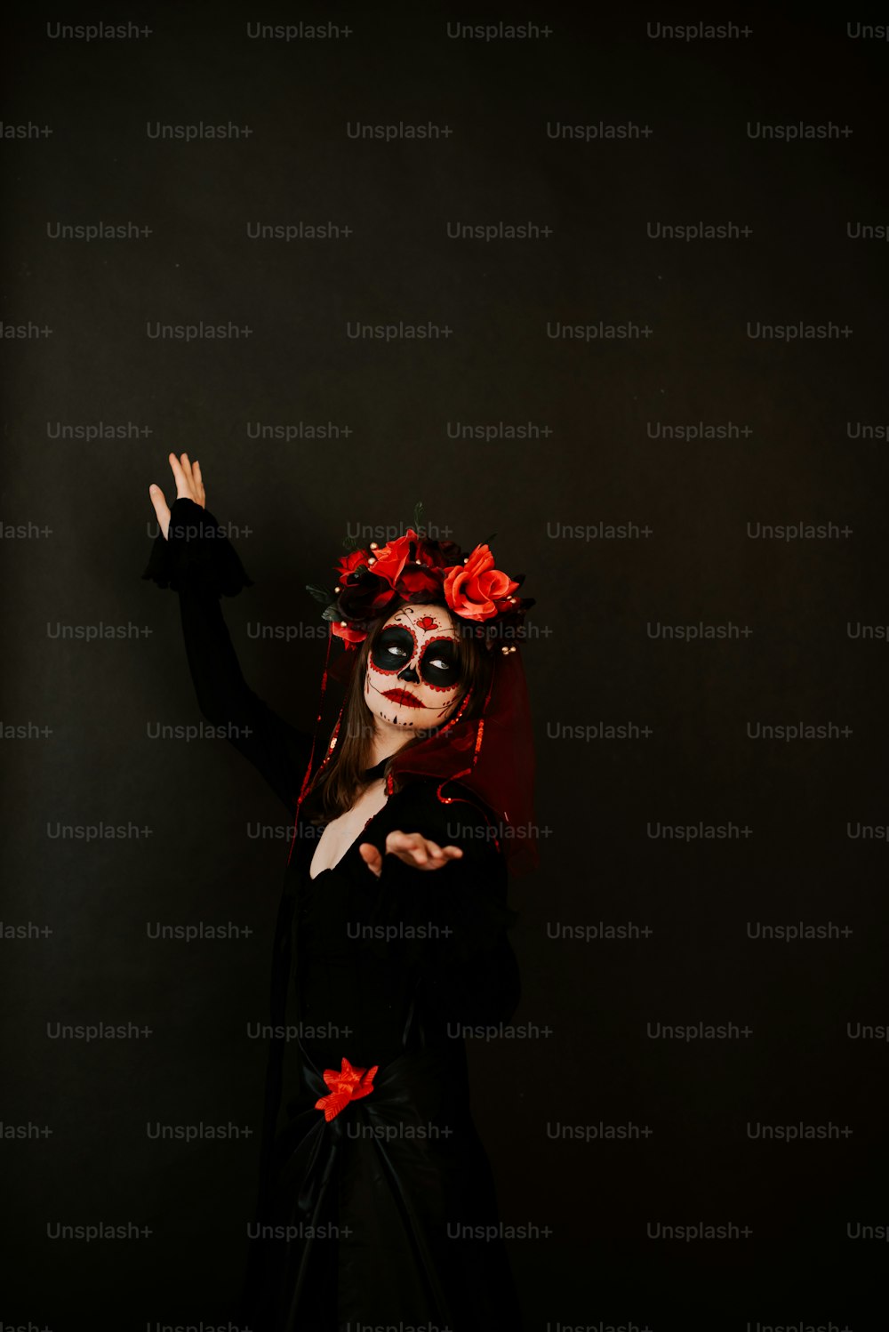 a woman in a black dress and red flowers on her head