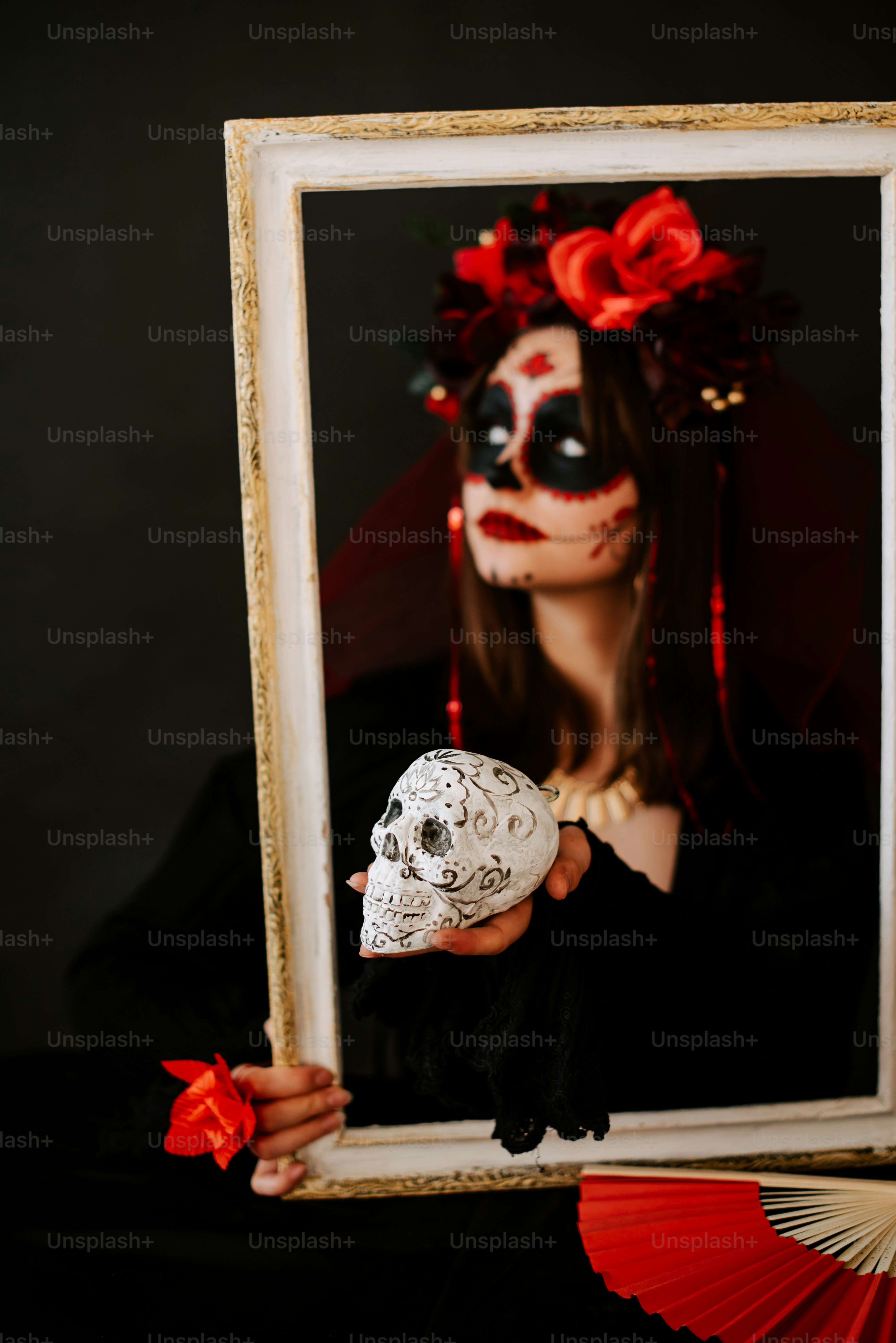 a woman holding a skull in front of her face