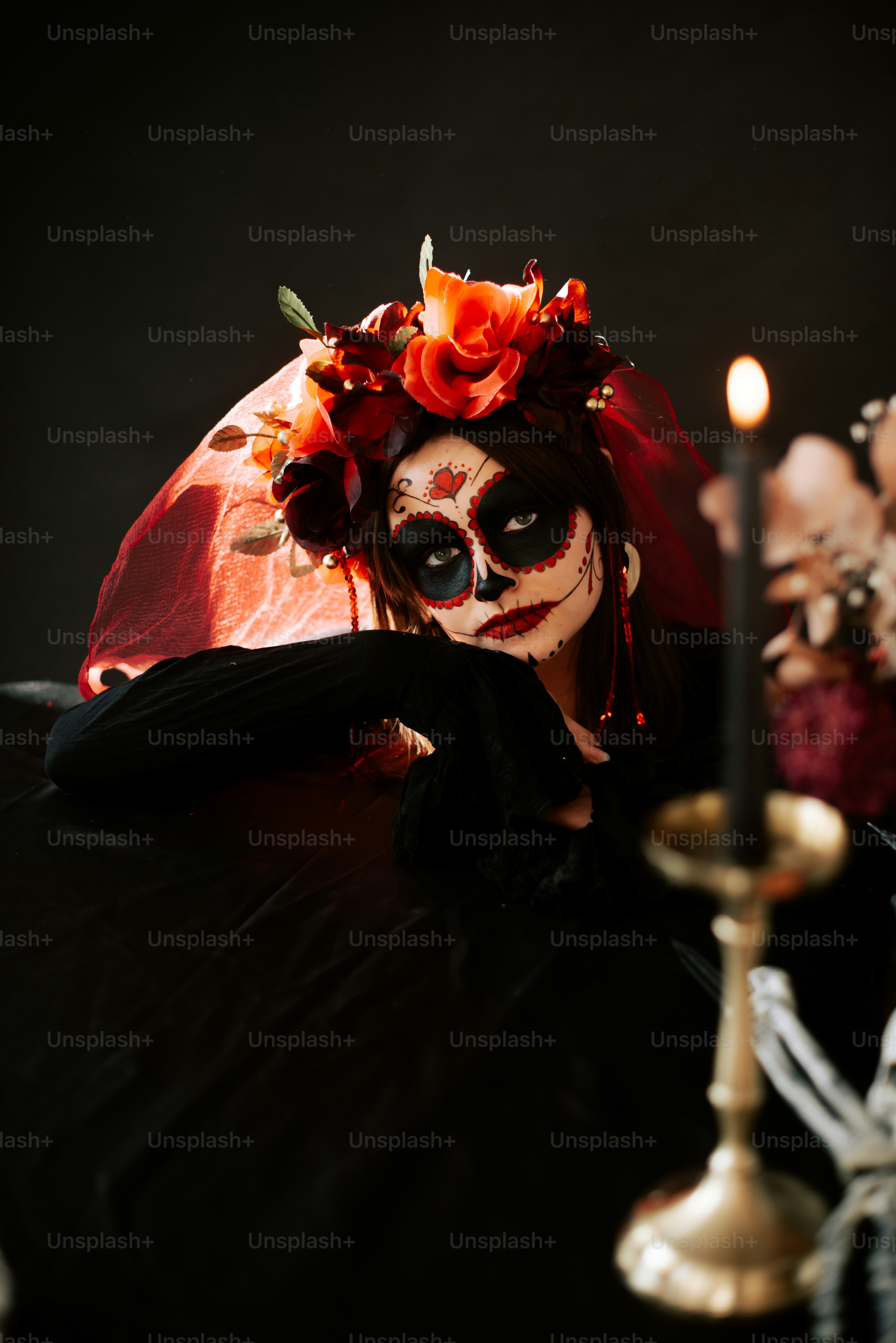 a woman wearing a skeleton makeup and holding a candle