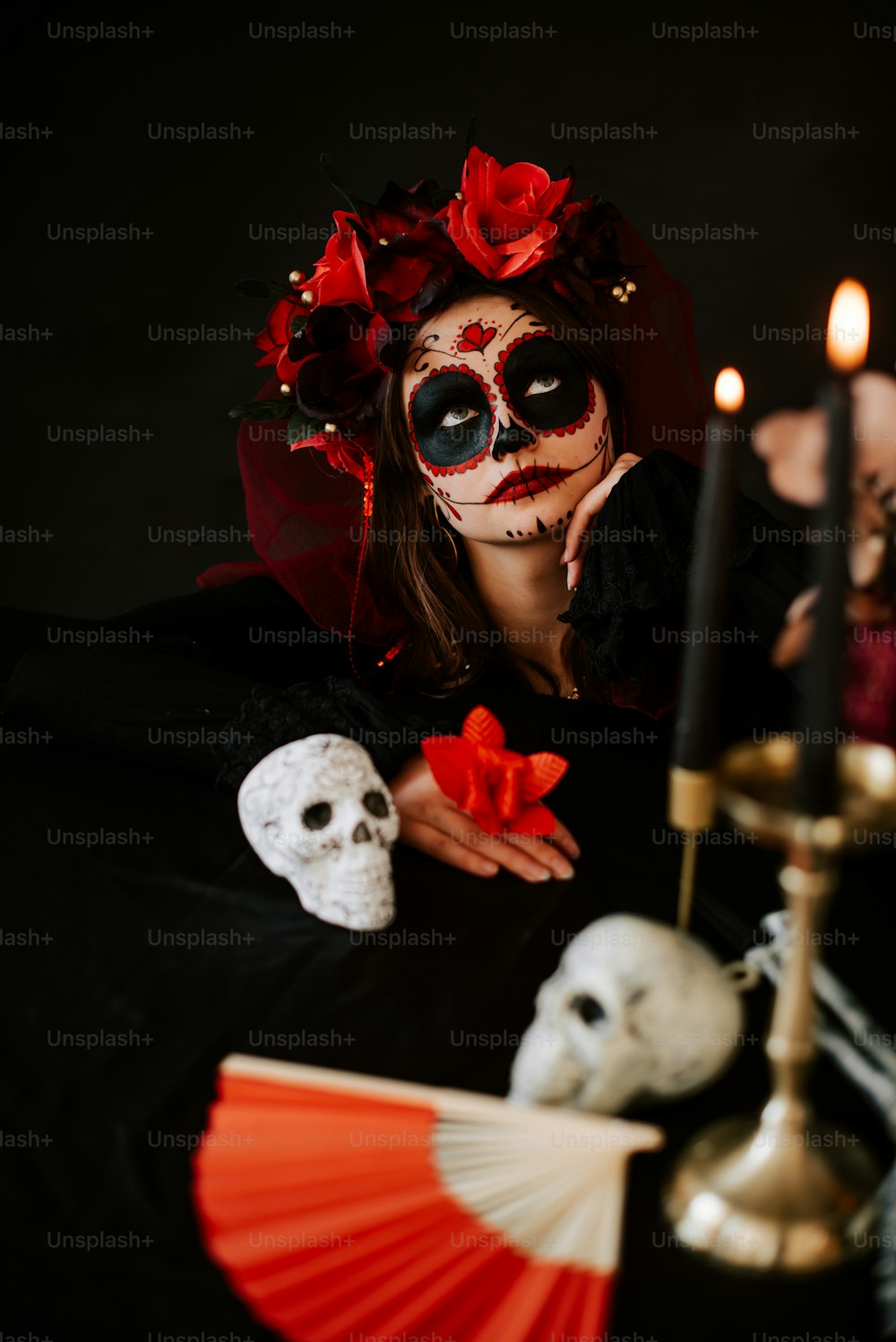 Una donna che indossa una maschera scheletrica e tiene in mano un ventaglio