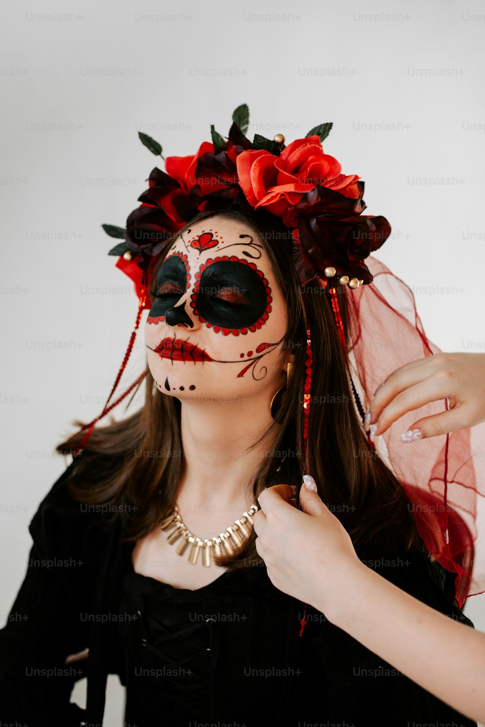 a woman wearing a black and red sugar skull makeup