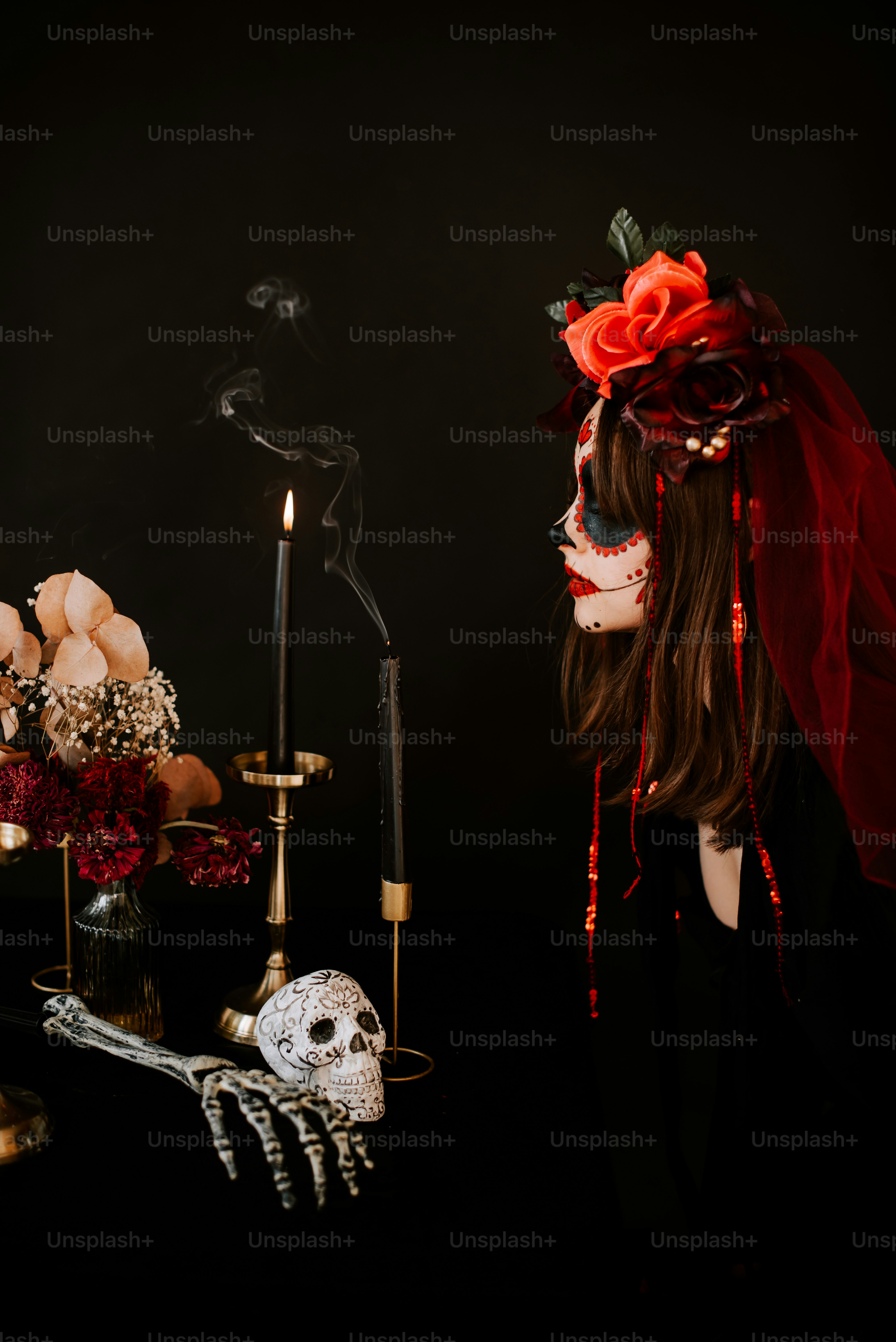 a woman wearing a skeleton mask and a red veil