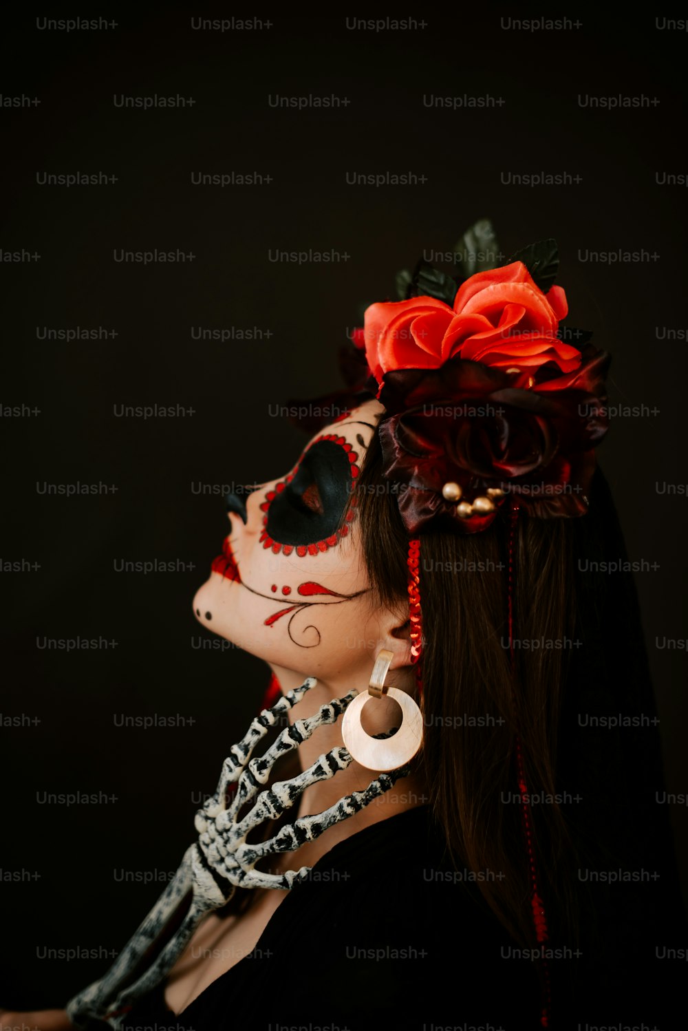 eine Frau, die eine Skelettmaske mit einer Blume im Haar trägt