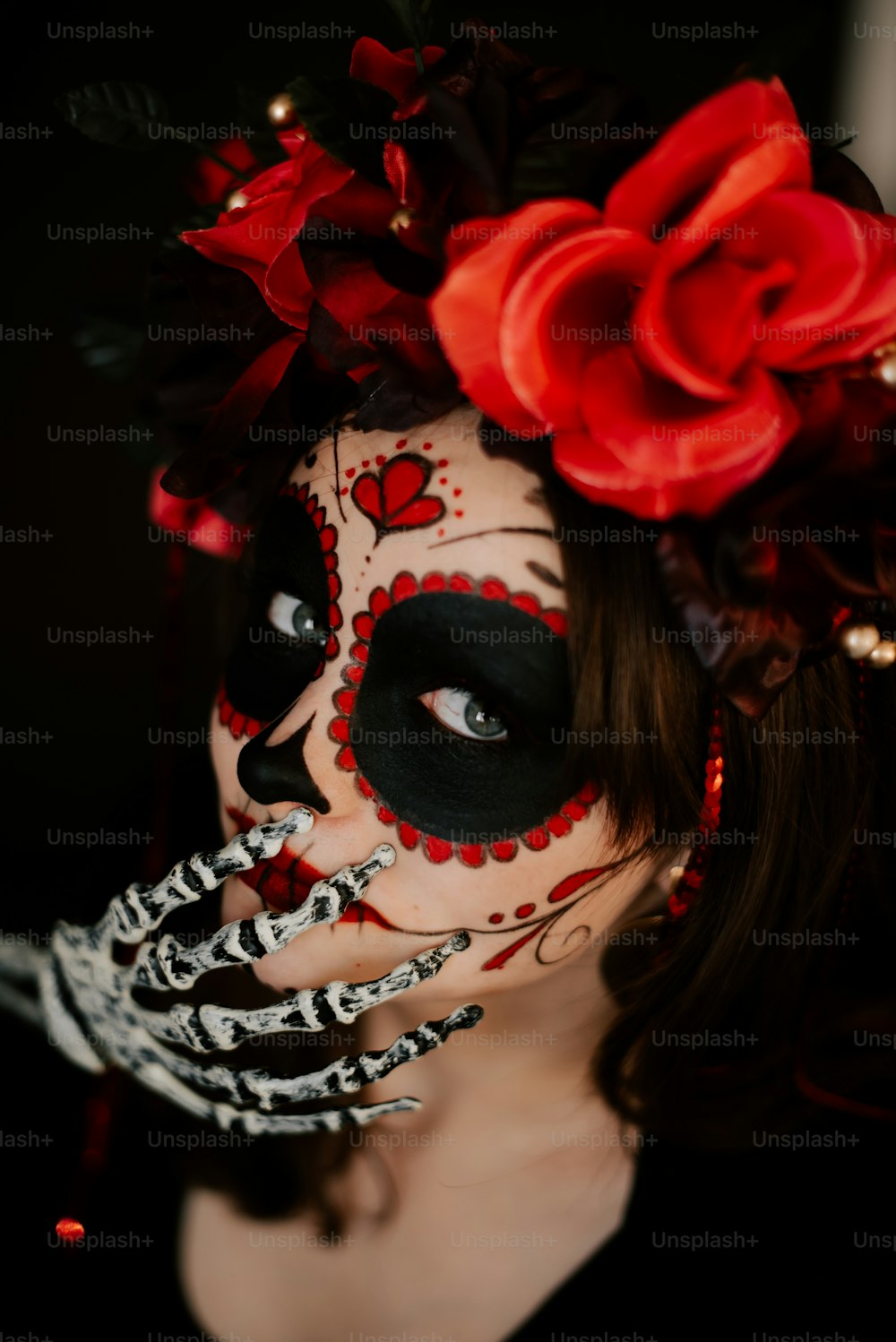 uma mulher com uma maquiagem de esqueleto e flores em seu cabelo
