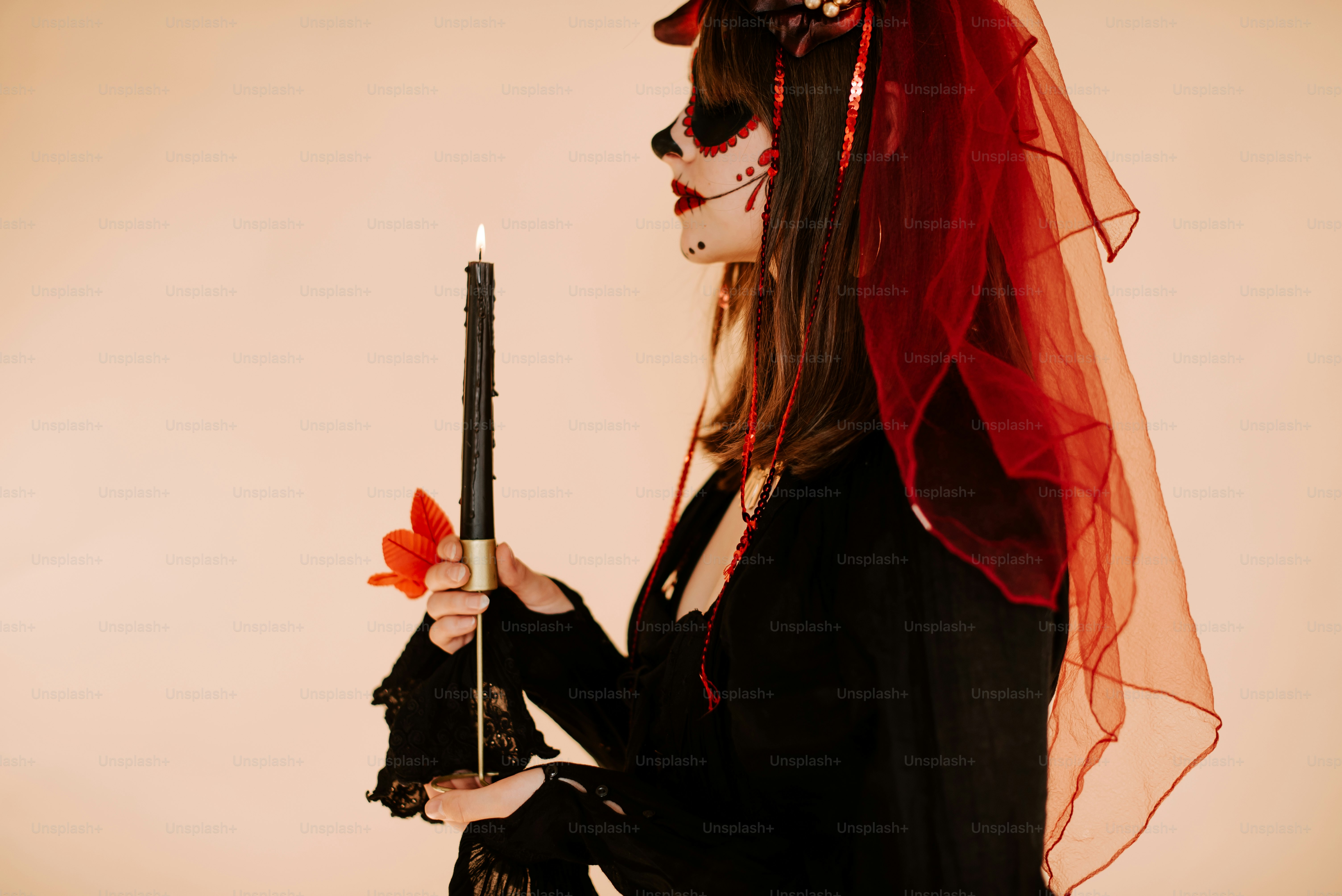 a woman dressed as a skeleton holding a candle