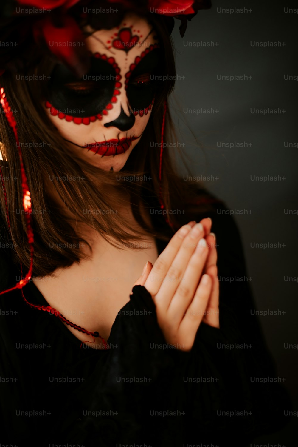 a woman wearing a mask and holding her hands together