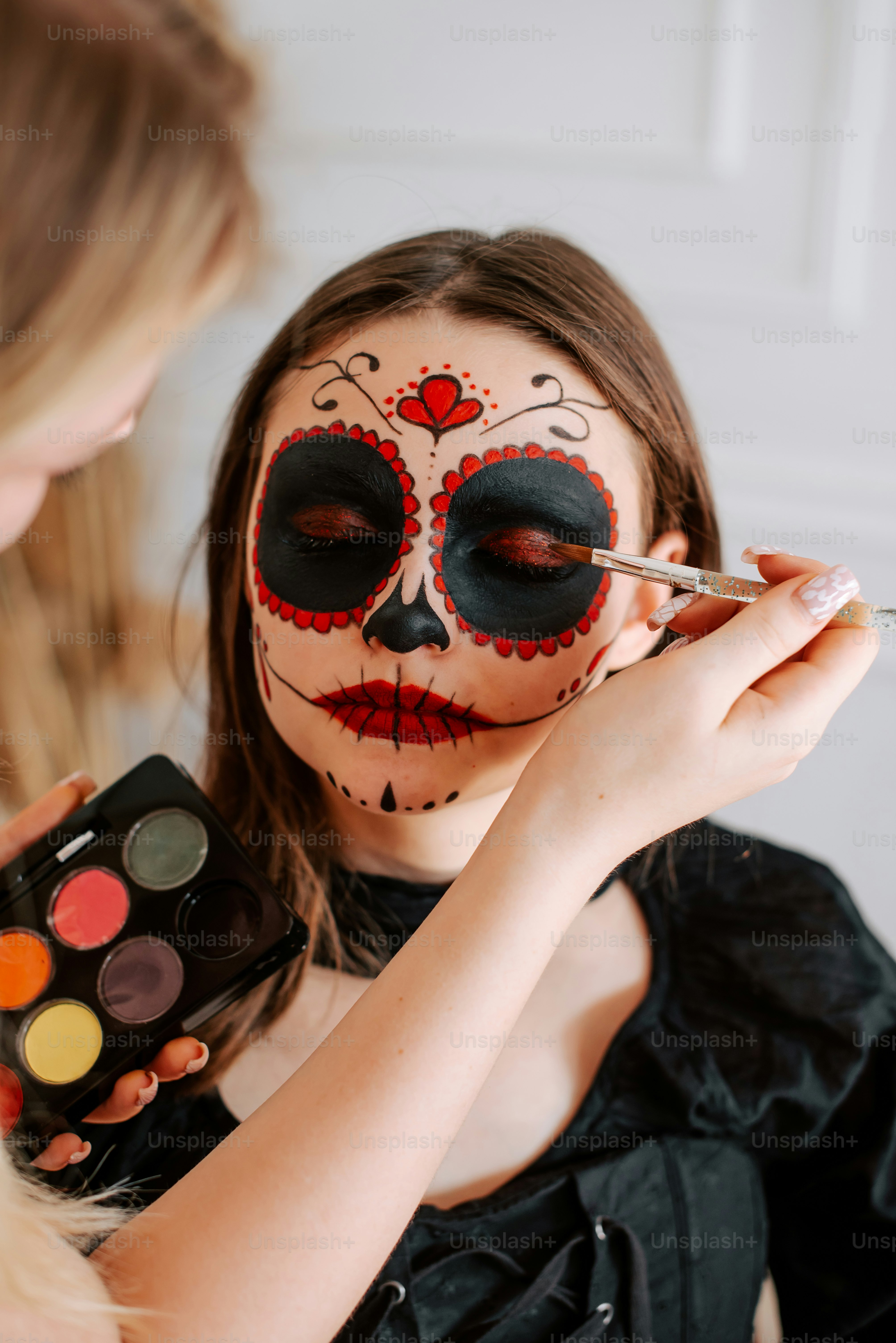 a woman is getting her face painted