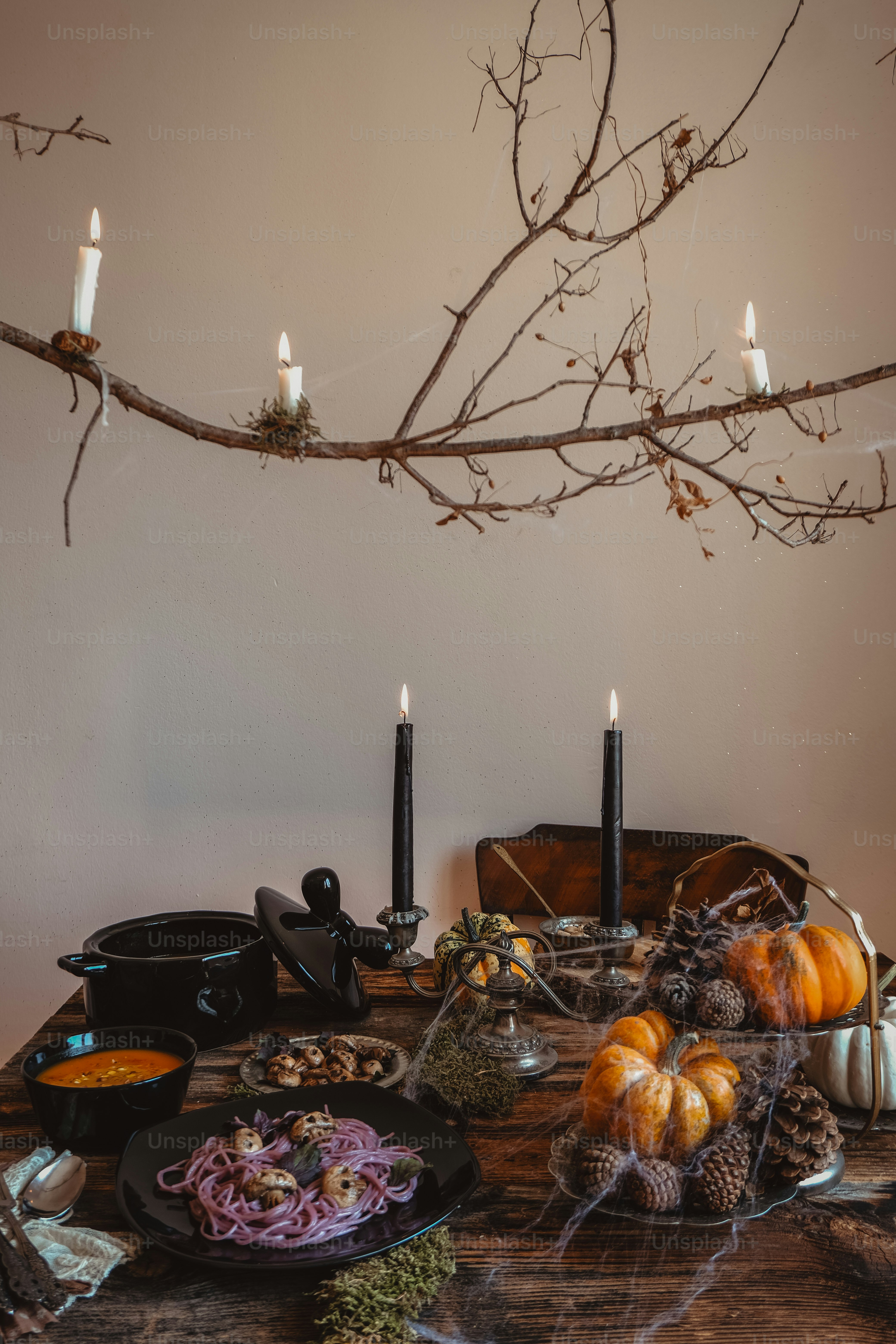 a table topped with plates of food and candles