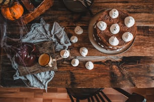 une table en bois surmontée d’un gâteau recouvert d’un glaçage blanc