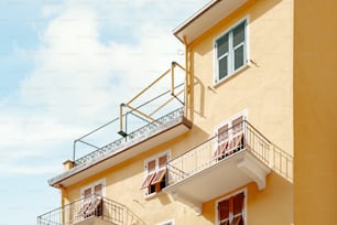 un alto edificio giallo con balcone e balconi