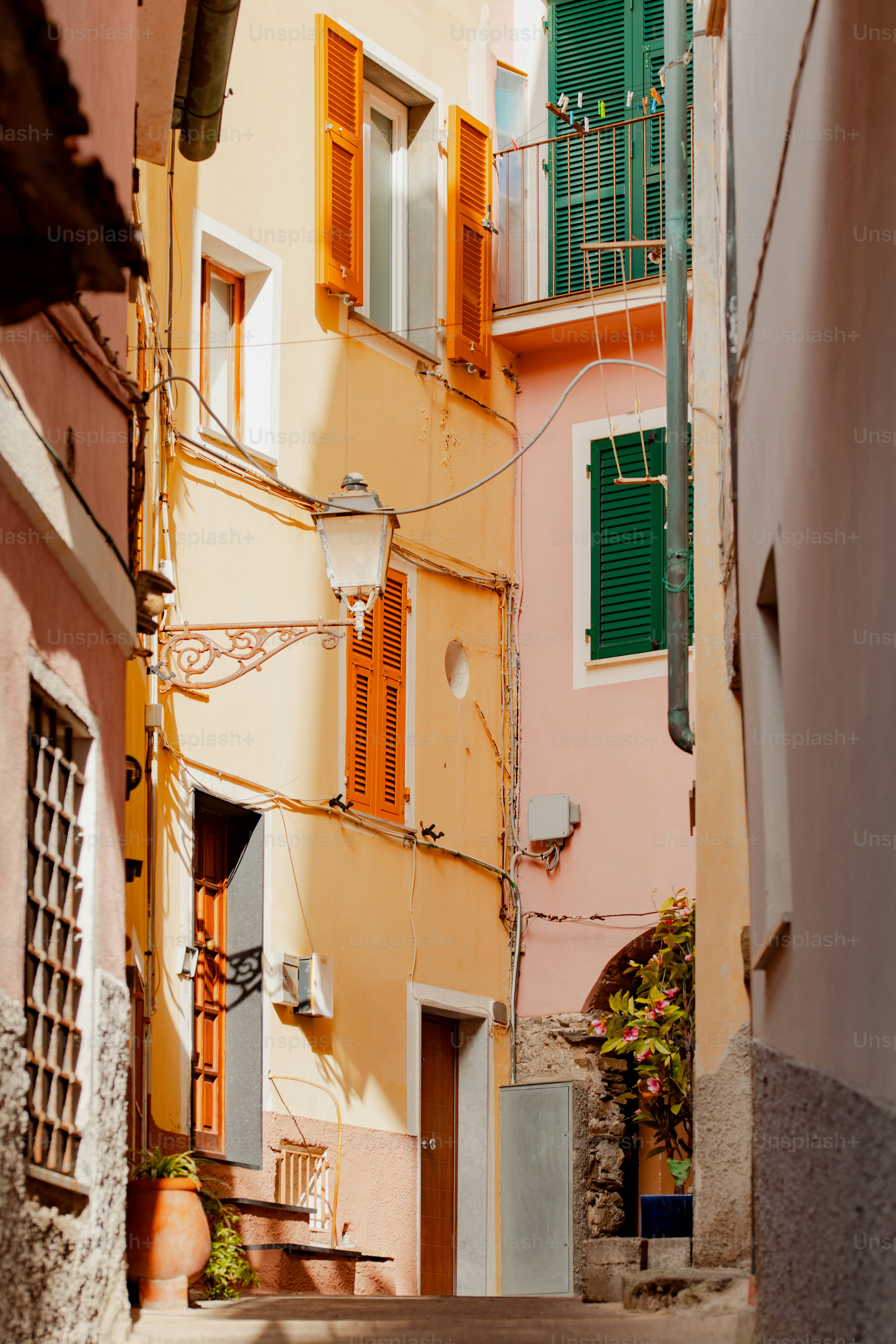 une ruelle étroite avec quelques bâtiments et volets verts