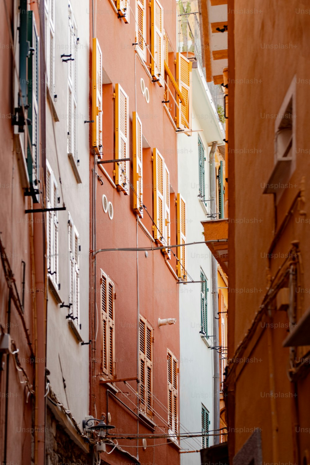 a narrow alleyway with many windows and shutters