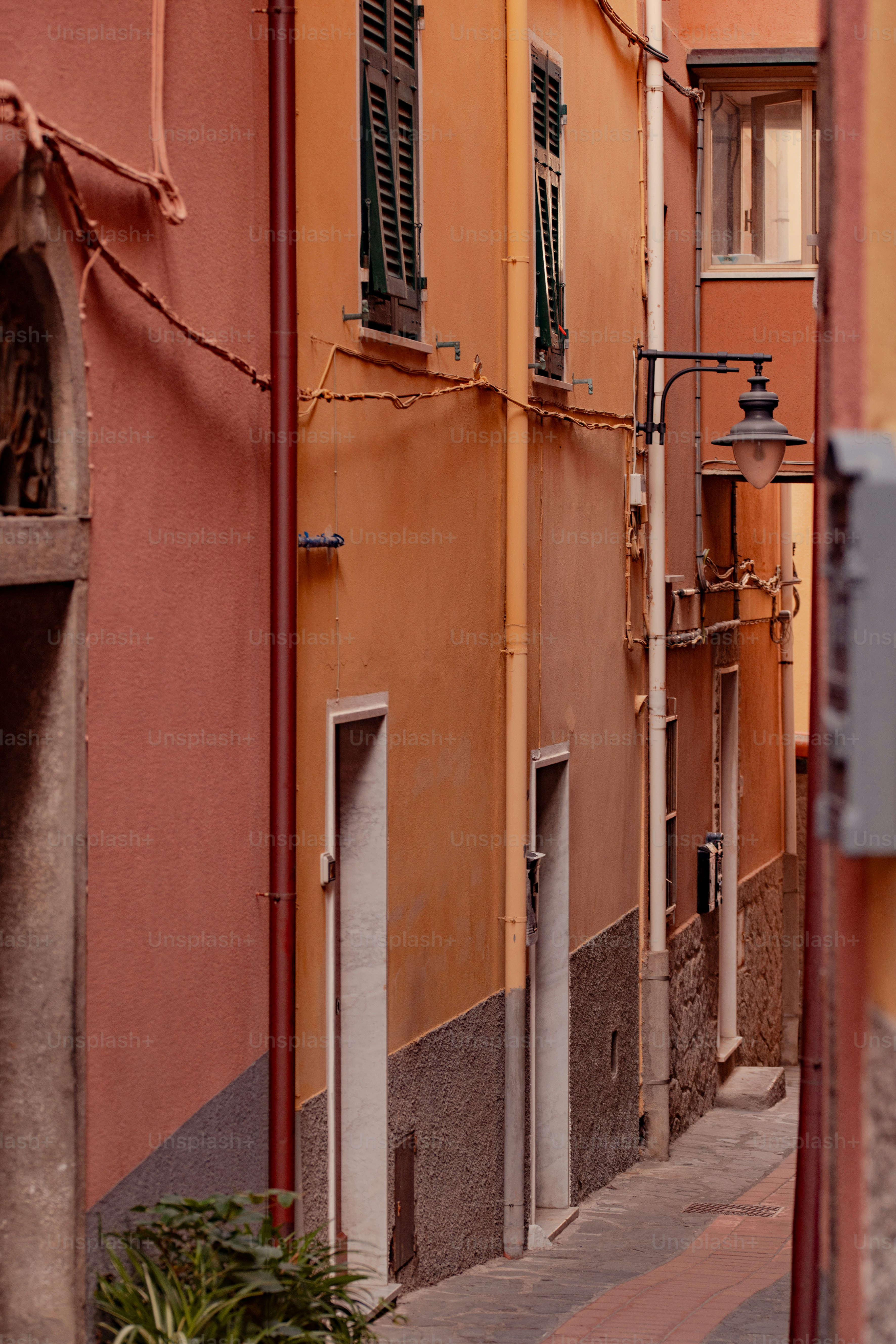 um beco com um relógio na lateral do edifício