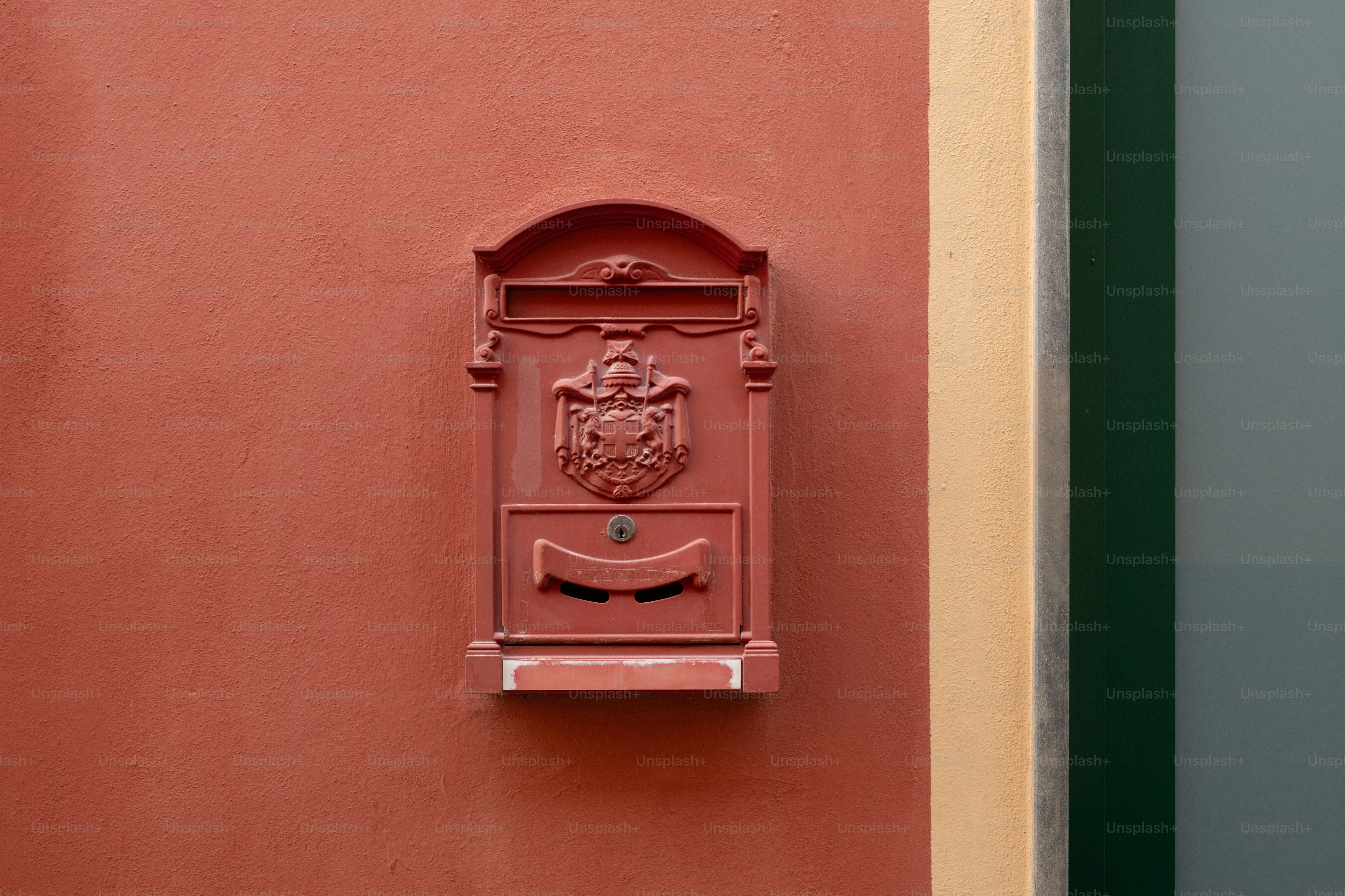 a red mailbox mounted to the side of a building