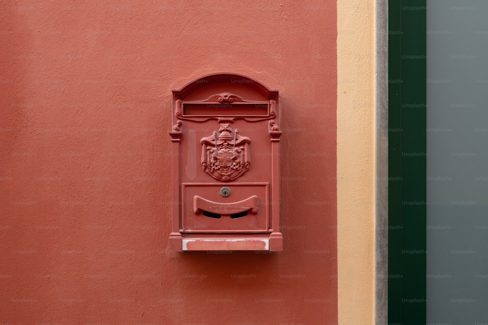 a red mailbox mounted to the side of a building