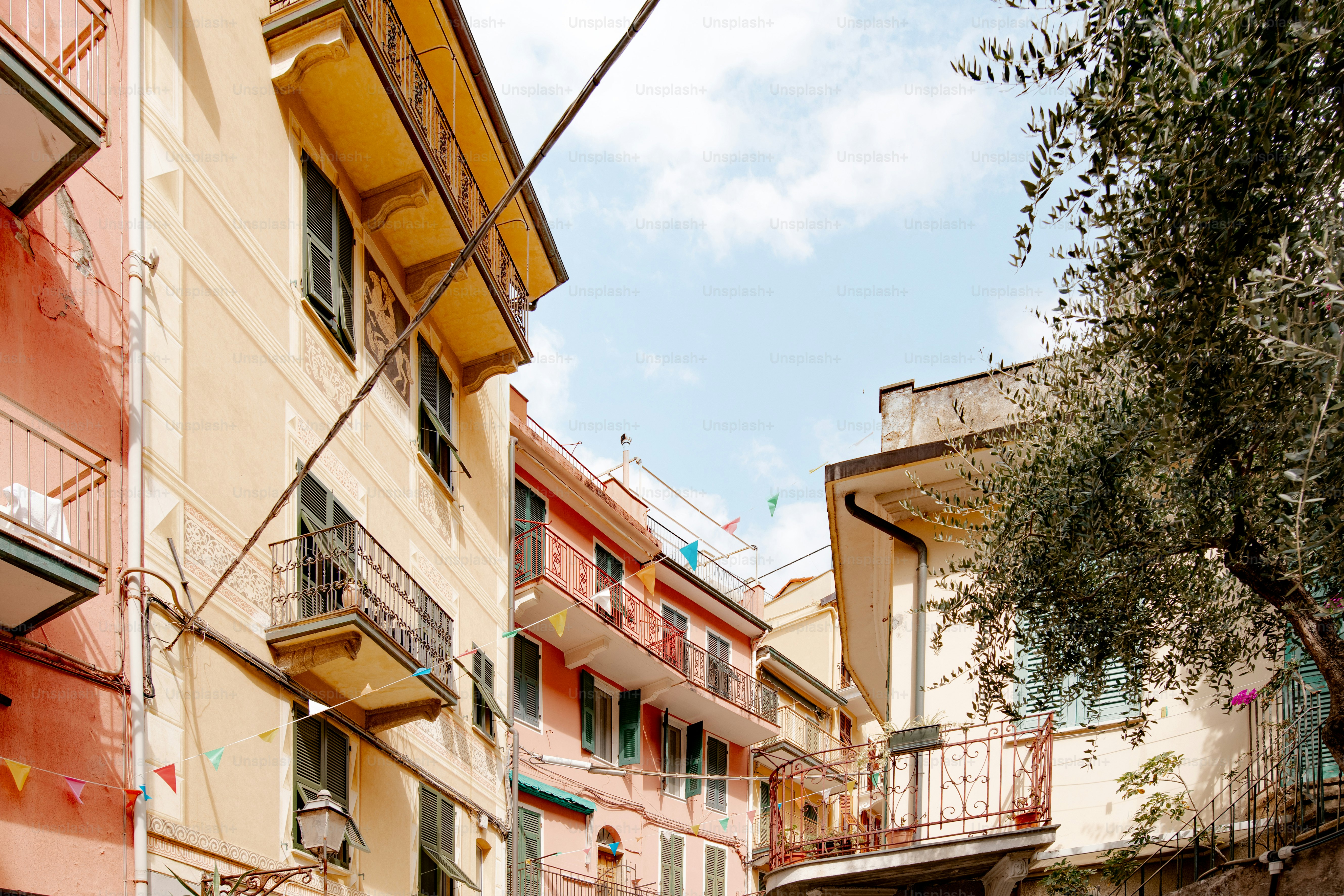 a narrow alley way with buildings and a tree