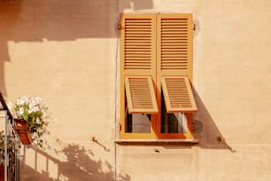 Ein Fenster mit hölzernen Fensterläden an einem Gebäude