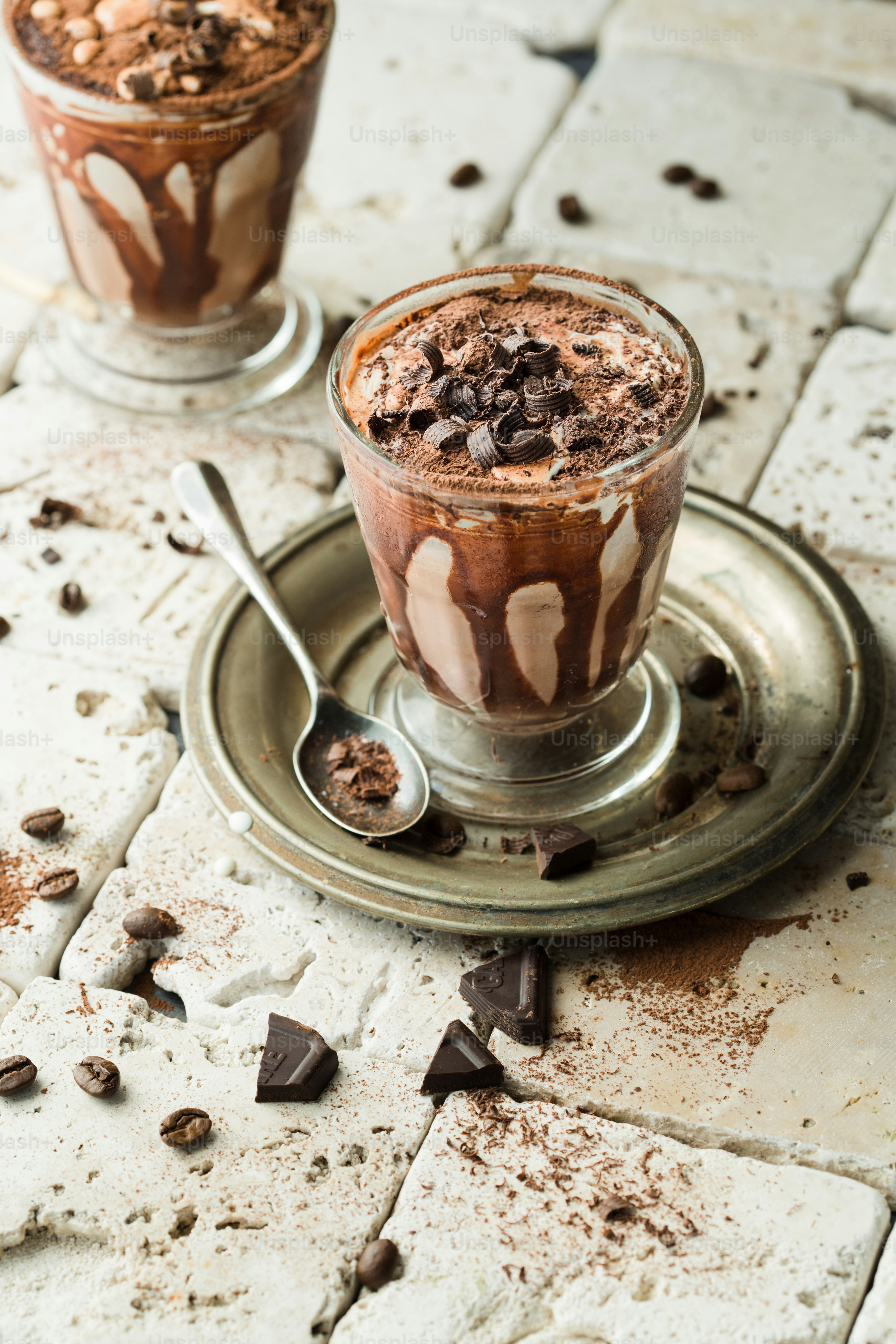 two glasses of chocolate dessert on a plate