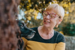 a woman with glasses is petting a dog