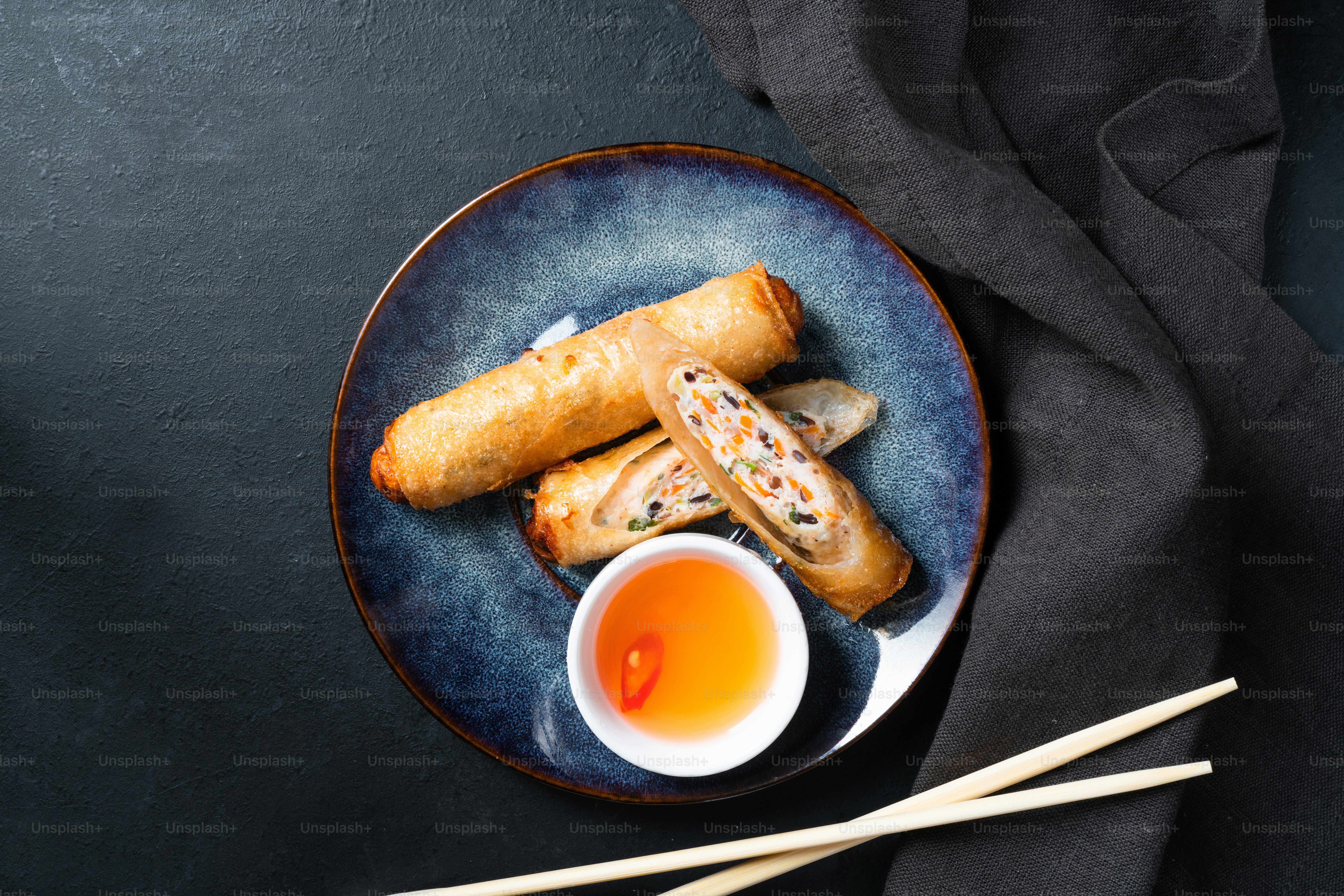 a plate of food with chopsticks and a cup of tea