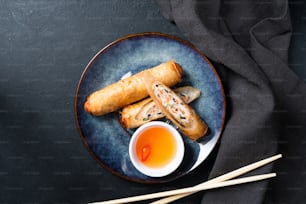 a plate of food with chopsticks and a cup of tea