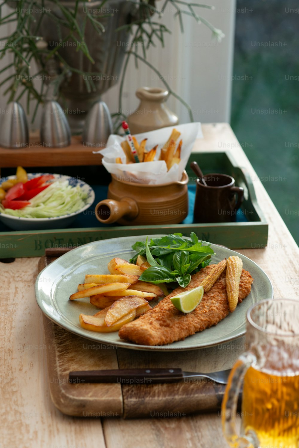 um prato de peixe e batatas fritas sobre uma mesa de madeira