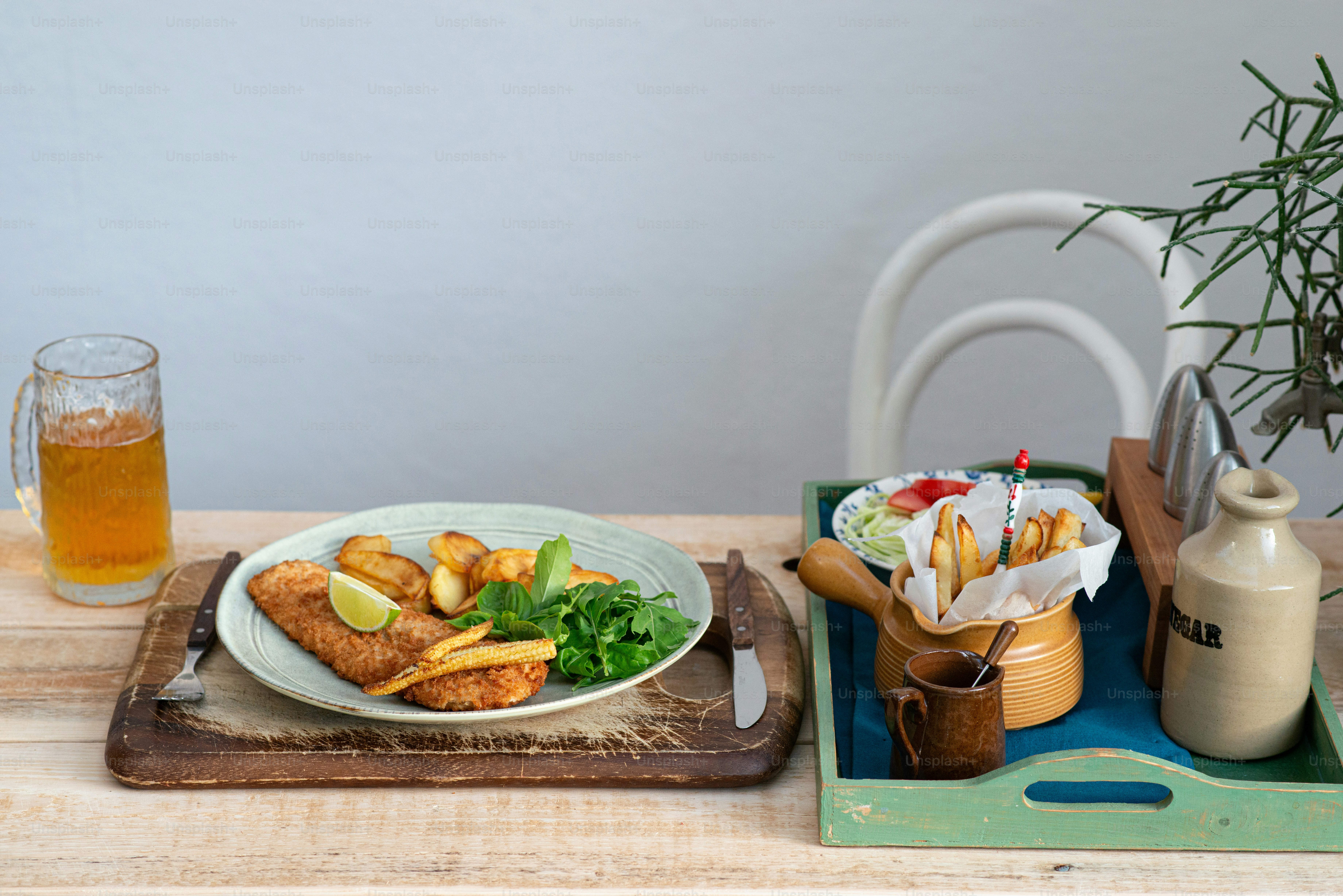 a plate of food and a glass of beer on a table