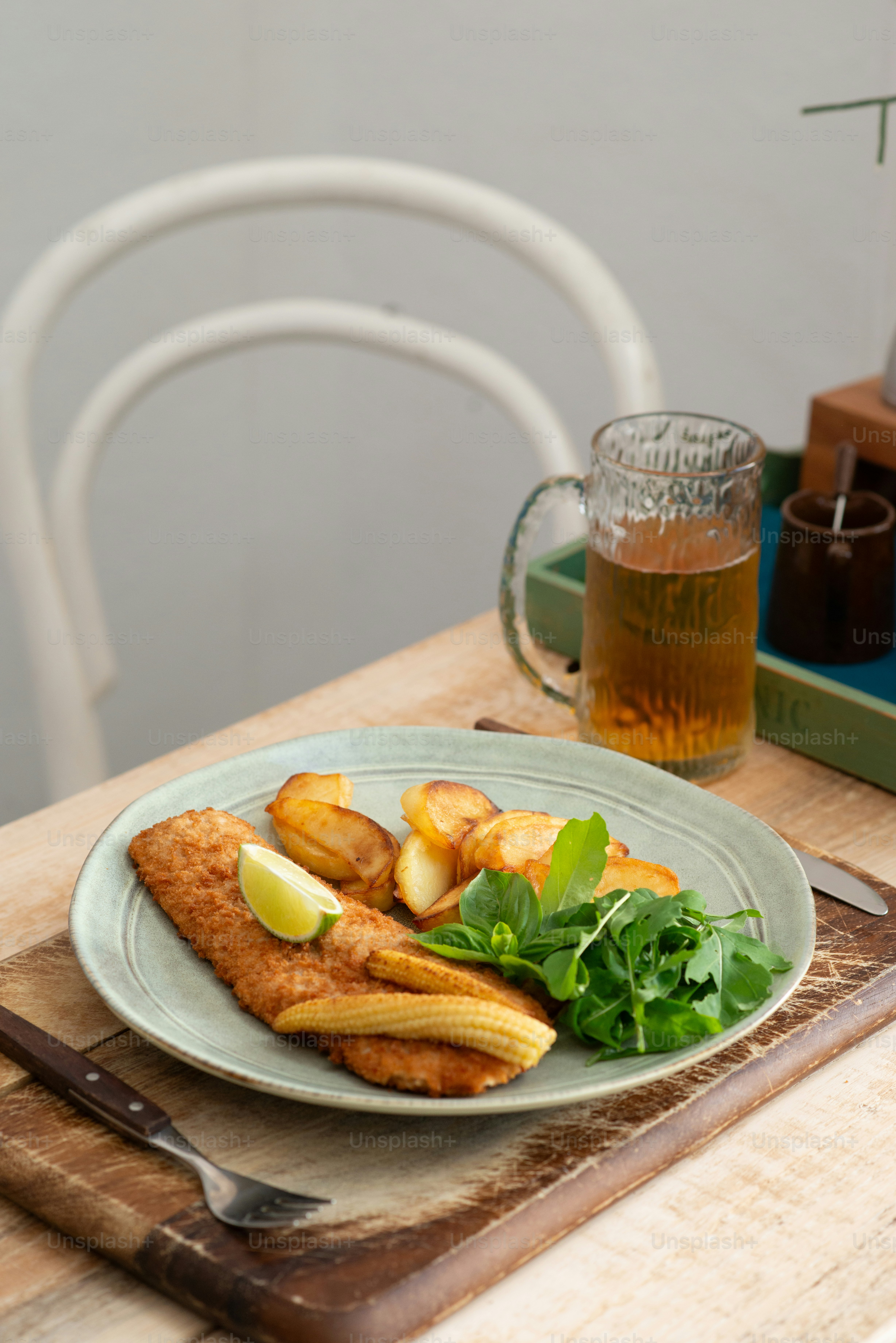 a plate of food on a table with a glass of beer