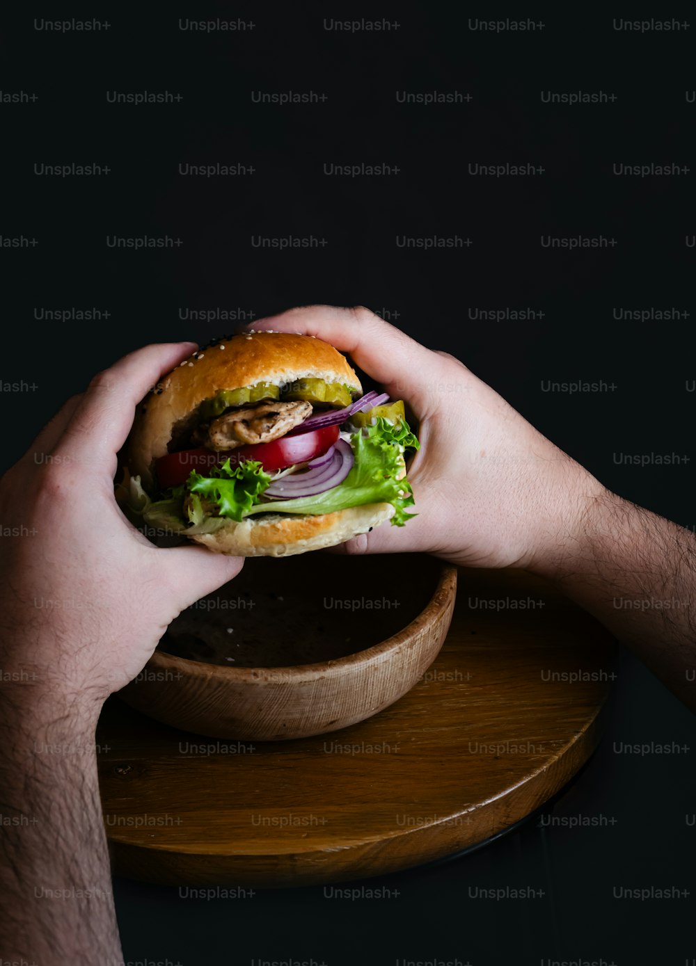 a person holding a sandwich in their hands