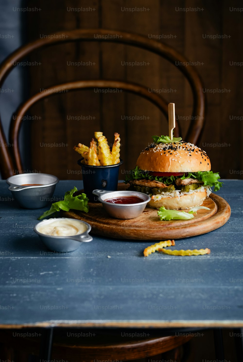 a hamburger and french fries on a wooden board