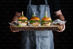 Un uomo che tiene un vassoio con tre panini su di esso