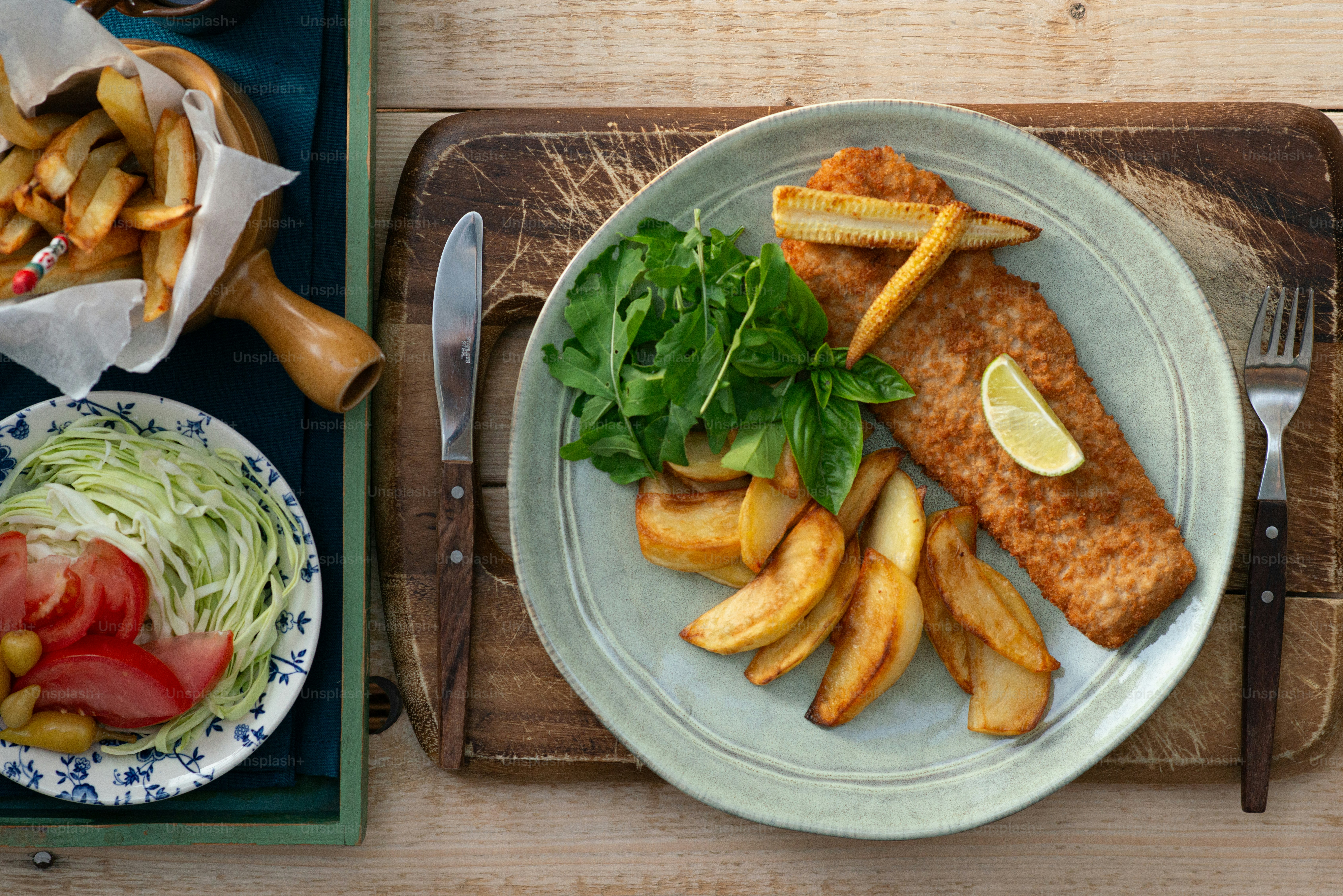 a plate of fish and fries with a side of salad