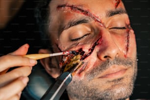 a man with a knife cutting through his face