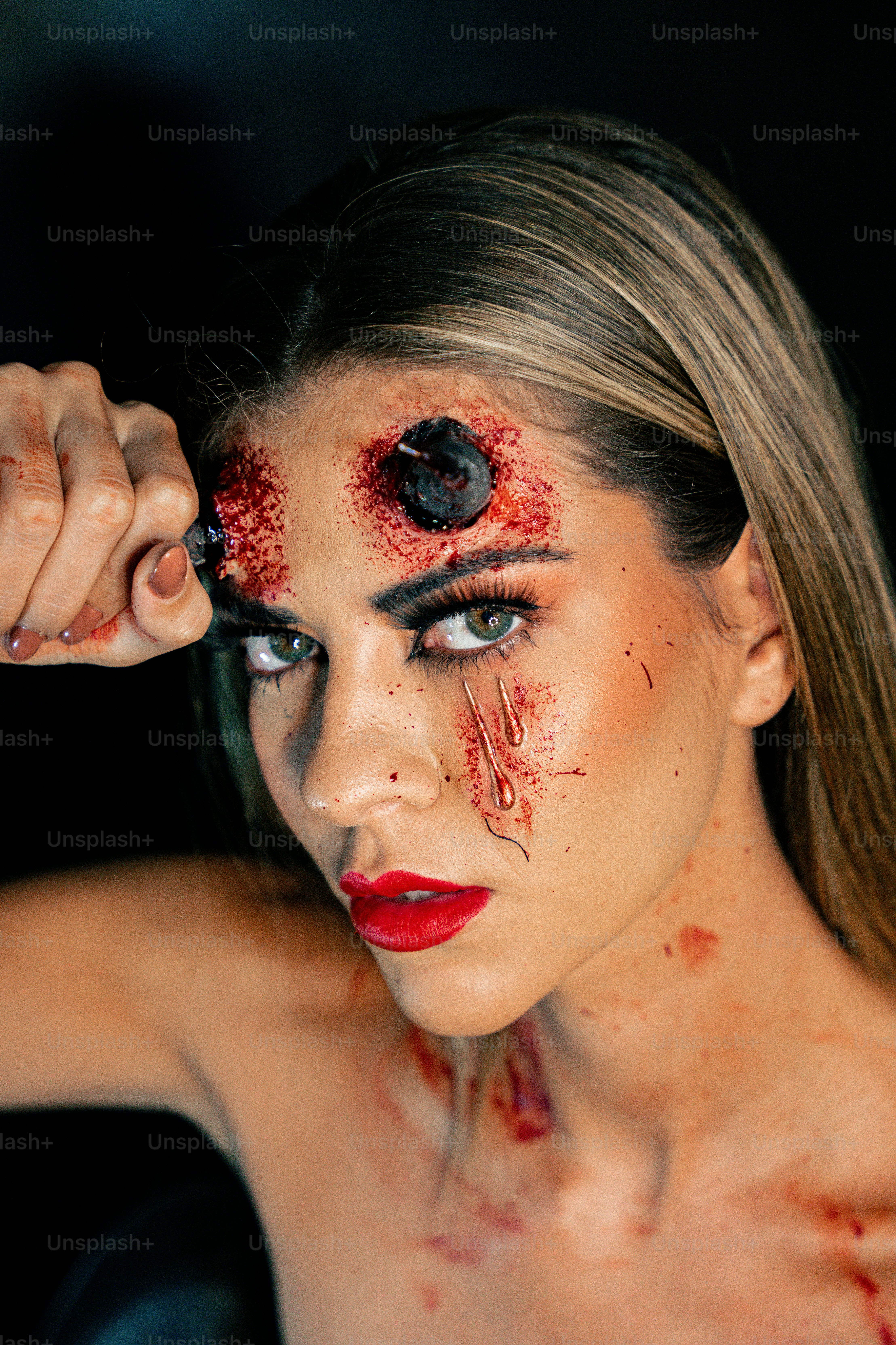 Una donna con il trucco e il sangue sul viso