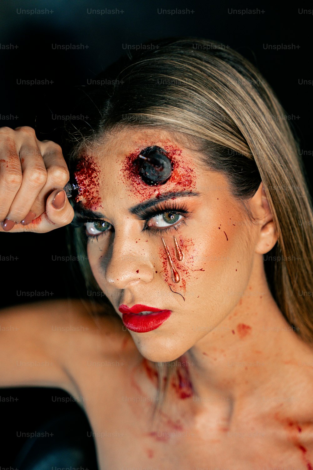 une femme maquillée et du sang sur le visage