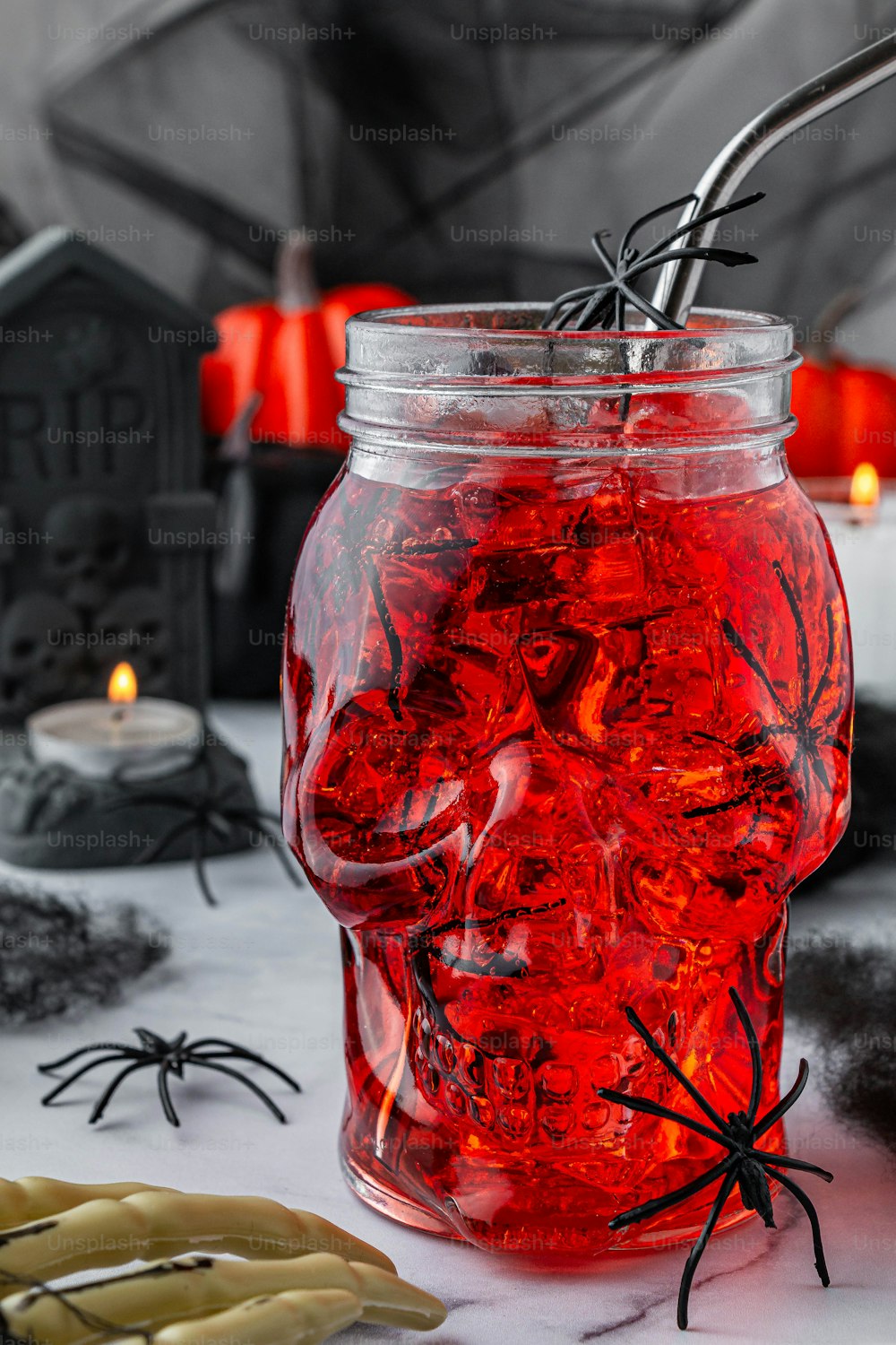 a jar filled with red liquid next to halloween decorations