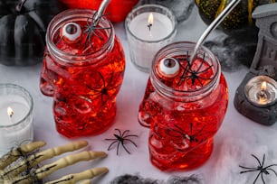 Une table surmontée de bocaux remplis de liquide et de décorations d’Halloween
