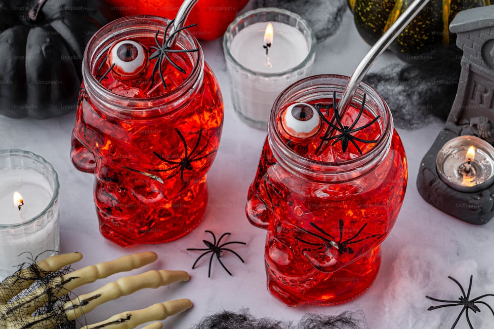 a table topped with jars filled with liquid and halloween decorations