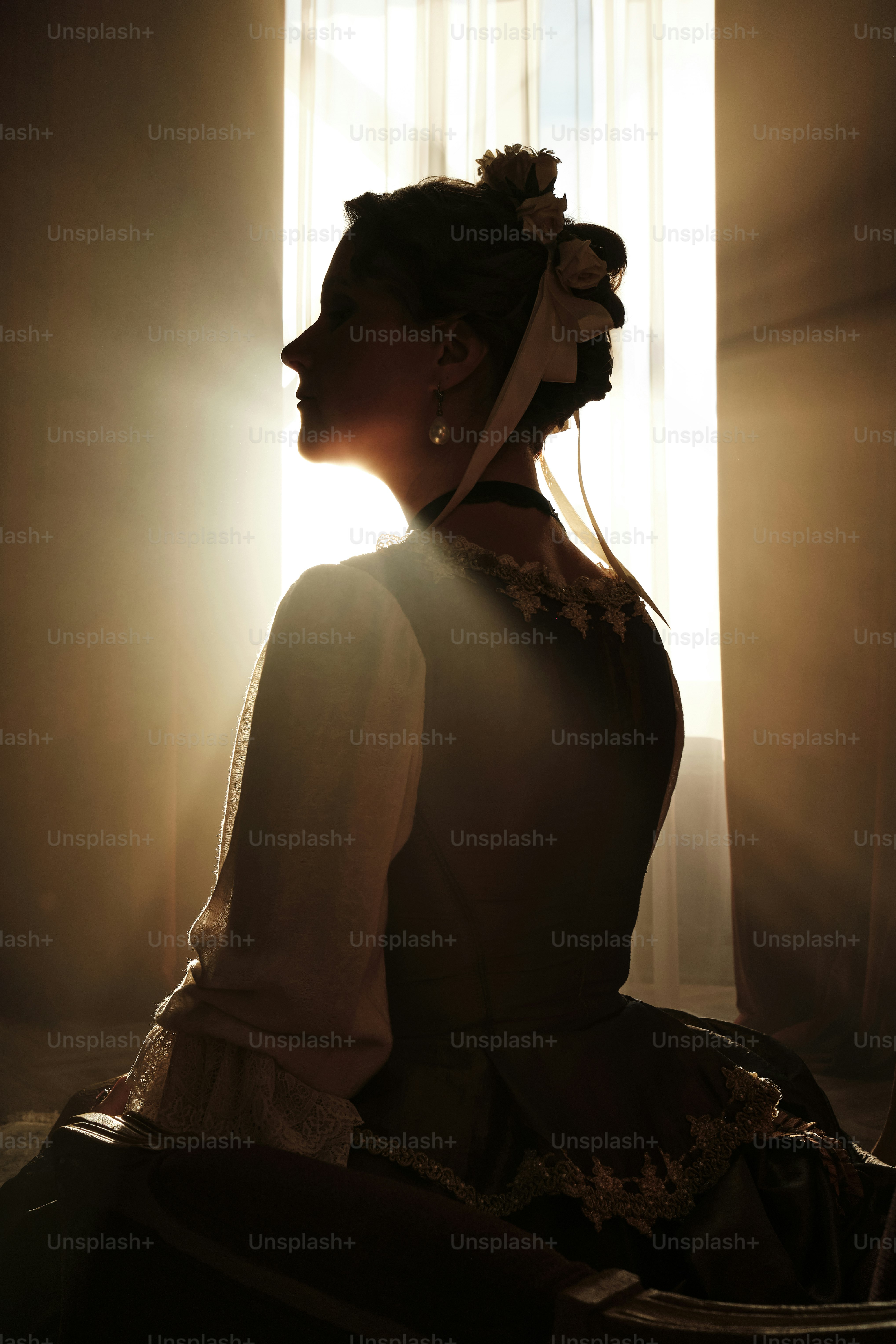 a woman sitting in a chair in front of a window