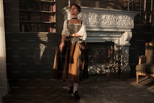 a woman in a dress standing in front of a fireplace