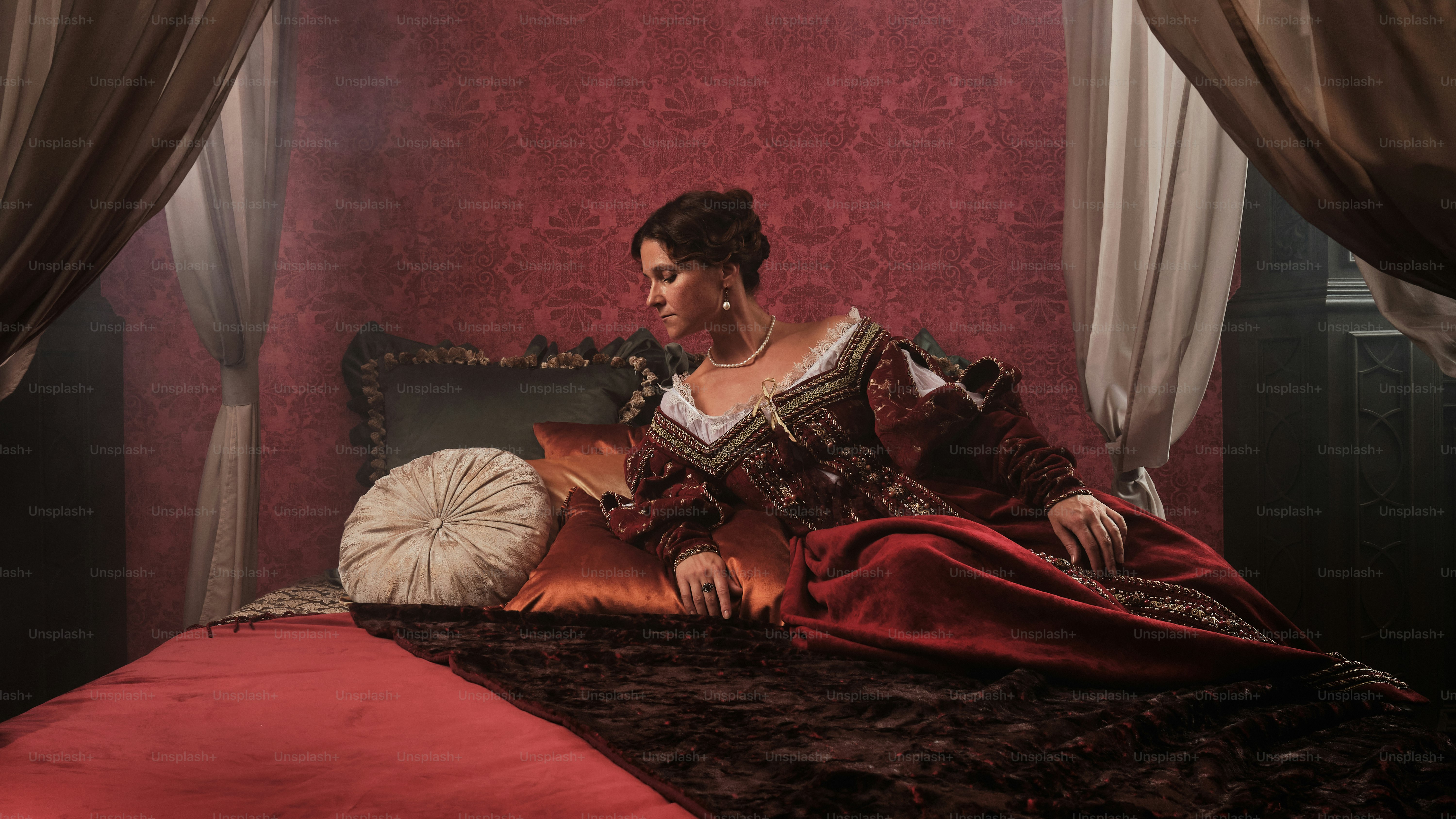 a woman sitting on a bed in a red room