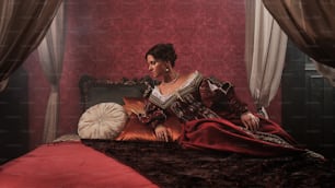 a woman sitting on a bed in a red room