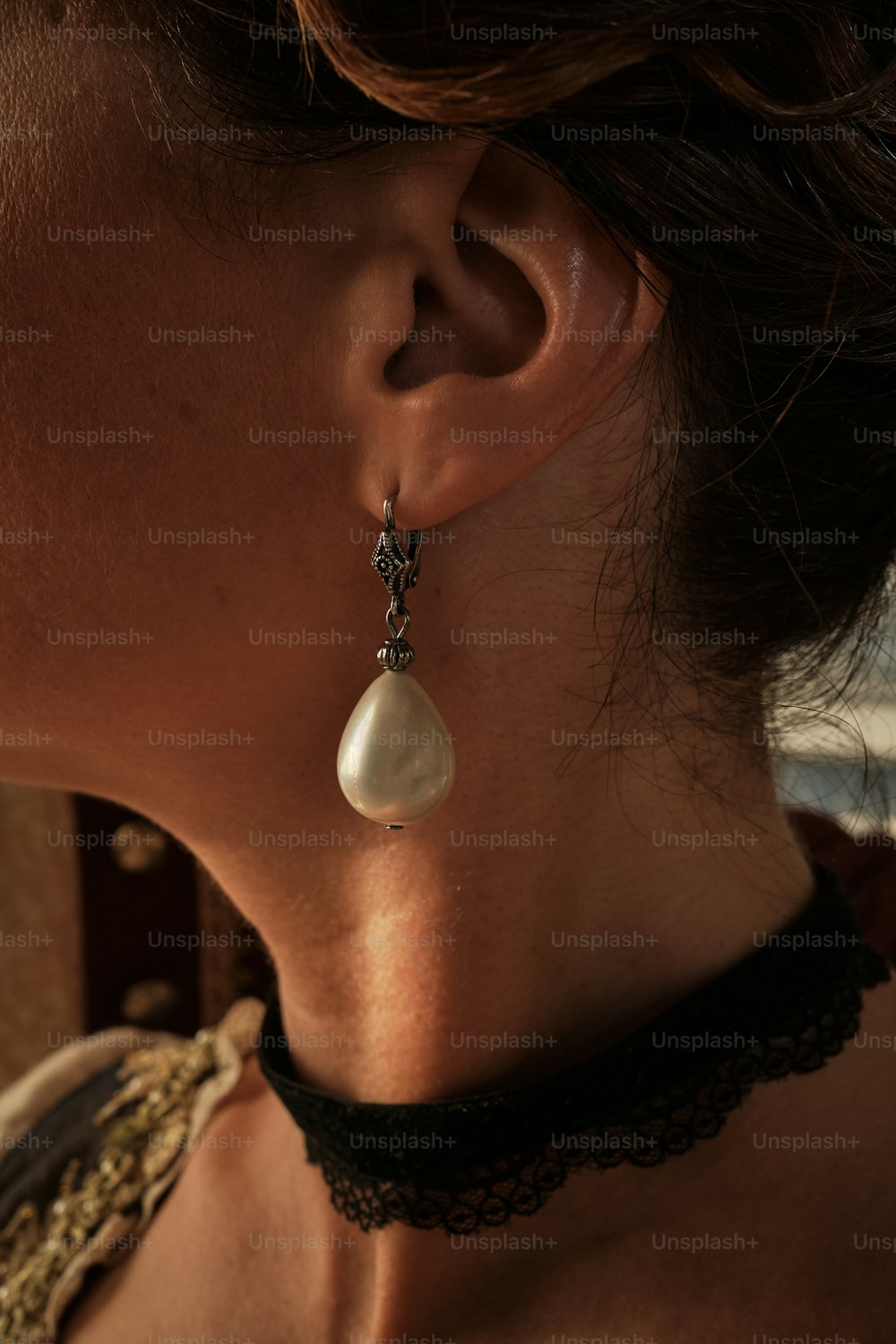 a close up of a person wearing a necklace and earrings