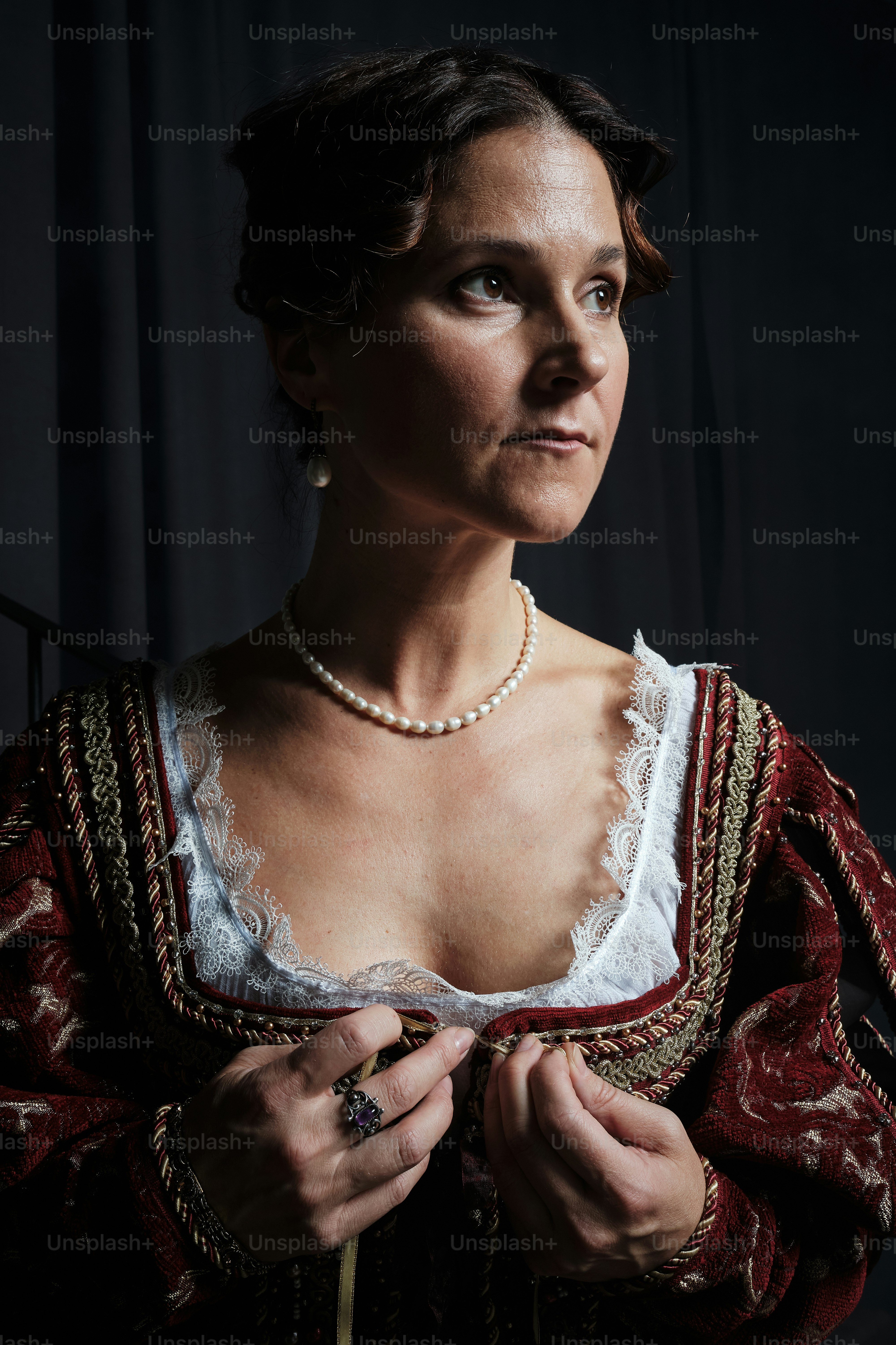 eine Frau in einem rot-weißen Kleid mit einer Perlenkette