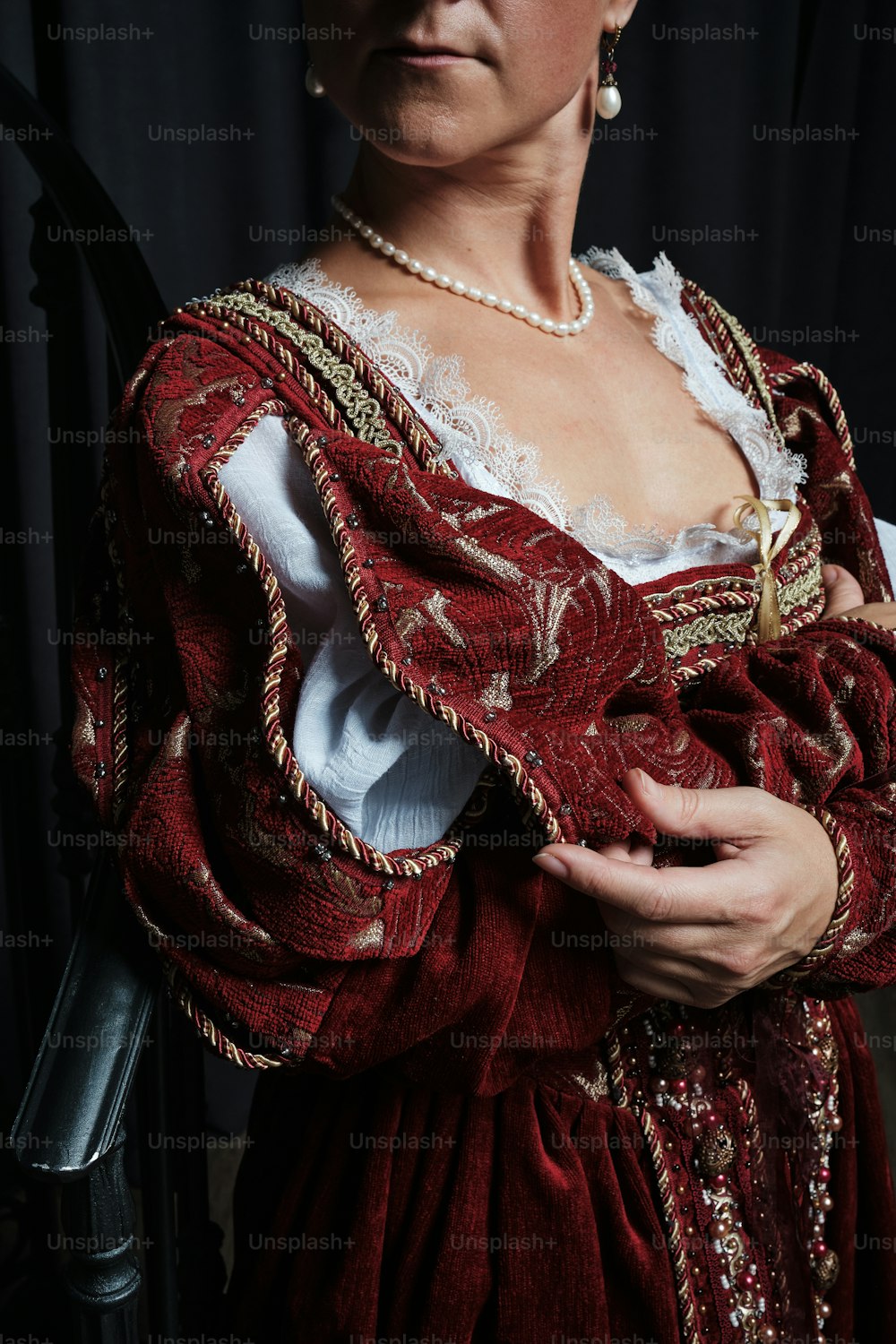 a woman wearing a red dress and pearls